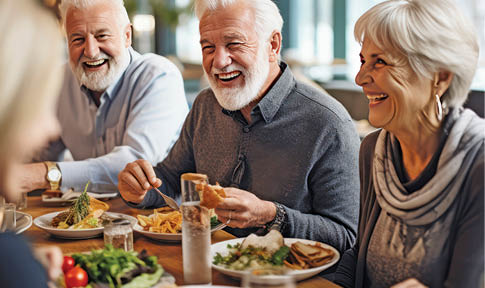 elderly friends eating dinner in restaurant.