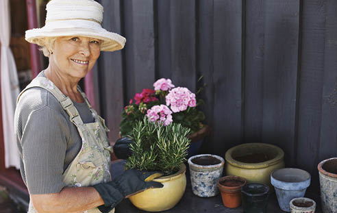 Senior woman planting flowers in a pot